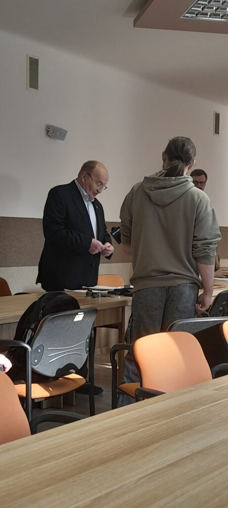 Andrzej Paszta udziela wywiadu dziennikarzowi Telewizji Orion. W tle inny uczestnik spotkania.